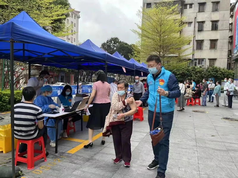 圖為江門宣傳系統黨員志愿者協助老人接種疫苗.jpg
